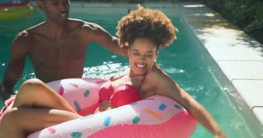 Çeşitli arkadaşlar güneşli bir günde havuz partisinden, gülmekten ve su sıçratmaktan zevk alıyorlar. Havuz başı, kutlama, yaz, tatil, boş zaman, açık hava