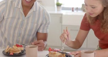 Elinde kahve fincanı olan genç bir adam, evinde, aydınlık mutfakta bir kadınla konuşuyor. Konuşma, iletişim, etkileşim, içecek, gündelik, arkadaşlık