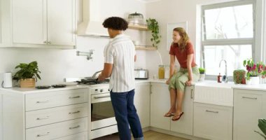 Modern mutfakta birlikte yemek pişiren, evde kaliteli vakit geçiren genç bir çift. Yemek hazırlama, kaynaşma, aşçılık, ev hayatı