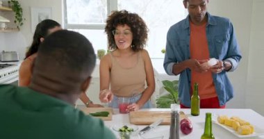 Çeşitli arkadaşlar mutfakta birlikte yemek hazırlar, yemek pişirmekten ve gülmekten zevk alırlar. dostluk, yemek hazırlama, takım çalışması, aşçılık, yerli, yaşam tarzı