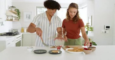 Çeşitli çiftler modern mutfakta birlikte taze meyve hazırlıyor, evde yemek pişirmenin tadını çıkarıyorlar. Yemek hazırlama, aşçılık, sağlıklı beslenme, takım çalışması, yaşam tarzı, yerli