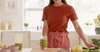 Mutfakta gülümseyen kadın günlük kıyafetler giyiyor, parlak sabah ışığının tadını çıkarıyor. Ev, yaşam tarzı, neşeli, mutluluk