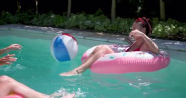 Havuzda dinlenen bir kadın, ferahlatıcı bir içecekle güneşli günün tadını çıkarıyor. Tatil, tatil, rahatlama, yaz, yüzme, içecek.