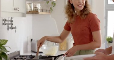 Çeşitli çiftler modern mutfakta birlikte yemek pişiriyor, evde kaliteli zaman geçiriyorlar ve gülüyorlar. Yaşam tarzı, ilişki, romantizm, birliktelik, aşçılık, kaynaşma