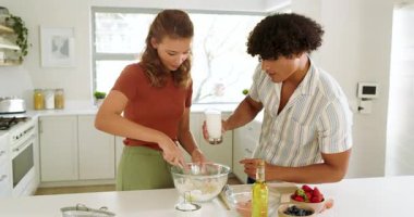 Parlak mutfakta birlikte yemek pişiren, malzemeleri karıştıran ve sürecin tadını çıkaran arkadaşlar. Takım çalışması, hazırlık, yaşam tarzı, aşçılık, tarif