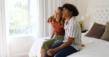 Mutlu çift yatakta oturuyor, parlak yatak odasında, evde sohbetin tadını çıkarıyorlar. mutluluk, ilişki, iletişim, sabah, bağlanma