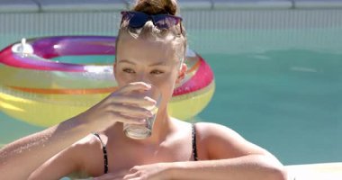 Havuzda dinlenen, güneş gözlüklü, fotokopi çeken bir kadın. Rahatlama, güneş ışığı, boş zaman, yaz, tatil, açık hava