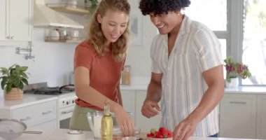 Mutfakta, çeşitli çiftler taze çilekle tatlı hazırlıyor, evde birlikte gülümsüyorlar. Pişirme, pişirme, aşçılık, mutluluk, ortaklık, birliktelik