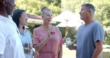 Sunny Garden 'da içki içip birlikte gülen kıdemli arkadaşlar. Arkadaşlık, eğlence, mutluluk, içecek.