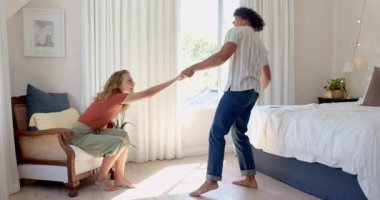 Parlak yatak odasında neşeyle dans eden çeşitli çiftler, evde, birlikte eğlenceli anların tadını çıkarıyorlar. Romantizm, mutluluk, ilişki, yaşam tarzı, bağ, ev