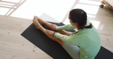 Evde yoga minderinde uzanan, esneklik ve rahatlamaya odaklanan bir kadın. fitness, wellness, meditasyon, egzersiz, yaşam tarzı, denge