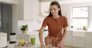 Yeşil smoothie 'yi cama dökmek, mutfakta sağlıklı yaşam tarzını kucaklayan bir kadın. Beslenme, sağIık, detoks, canlılık, organik, taze