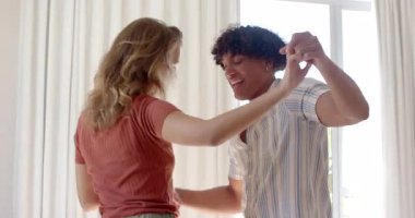 Çeşitli çiftler evde neşeyle dans ediyor, arkadaşlıklarından keyif alıyor ve gülümsüyor. Mutluluk, romantizm, yaşam tarzı, kutlama, oturma odası, ilişki