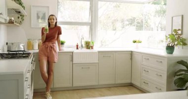 Mutfakta rahat bir kadın tezgahta duruyor, huzurlu bir sabah anının tadını çıkarıyor. Yaşam tarzı, kahvaltı, sabah rutini, dinlenme, huzur, rahatlık.