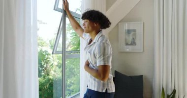 Genç adam açık pencerede duruyor, temiz havanın ve doğal ışığın tadını çıkarıyor, evde. Düşünce, rahatlama, sükunet, sağIık, huzur, çevre