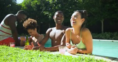 Güneşli bir günde havuz başında gülen ve eğlenen farklı arkadaşlar. Kutlama, dostluk, eğlence, tatil, rahatlama, yaz