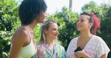 Üç farklı bayan arkadaş havuz başında sohbet ediyor ve birlikte gülüyorlar. Arkadaşlık, rahatlama, sohbet, yaz, tatil, boş zaman