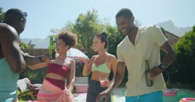 Izgara sebze ve dans, arka bahçede çeşitli arkadaşlar ellerinde içkilerle barbekü. Sosyalleşme, açık hava, eğlence, yaz, kutlama, eğlence