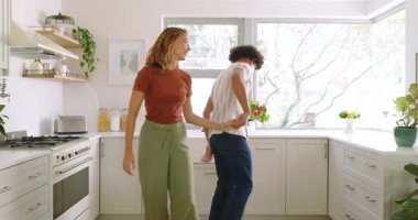 Parlak mutfakta dans eden mutlu çift, evde sabah rutininin tadını çıkarıyorlar. Yaşam tarzı, dans, romantizm, ilişki, evcil, mutluluk