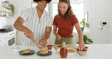 Kahvaltı hazırlamak, çeşitli çiftler çilek dilimlemek ve evde mutfakta krep istiflemek. Yemek pişirme, sabah, yemek hazırlama, aşçılık, takım çalışması, taze