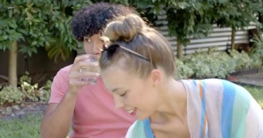 Güneşli bir günde havuz kenarında içkileri yudumlarken gülümseyen farklı çiftler. Rahatlama, tatil, rahatlama, mutluluk, yaz, açık hava