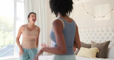 Çeşitli bayan arkadaşlar evlerinde rahat yatak odasında doğal ışık ve yumuşak dekorla neşeyle sarılıyorlar. Arkadaşlık, birliktelik, bağlılık, sıcaklık, rahatlık, samimiyet.