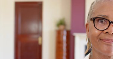 Gözlüklü yaşlı bir kadın, evinde sıcak bir şekilde gülümsüyor, neşeli bir ifade sergiliyor, kopyalama alanı. Yaşlılar, mutluluk, yaşam tarzı, neşeli, ev