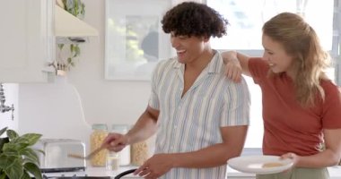 Genç ve çeşitli çiftler mutfakta birlikte kahvaltı hazırlıyor, keyifli anlarını evde paylaşıyorlar. Beraberlik, ilişki, bağlanma, aile içi, aşçılık