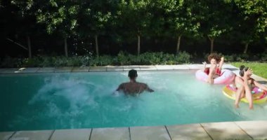 Çeşitli arkadaşlar havuzda dinleniyor, güneşli günlerin tadını çıkarıyor ve birlikte gülüyorlar. Boş zaman, tatil, eğlence, yaz, arkadaşlık, rahatlama