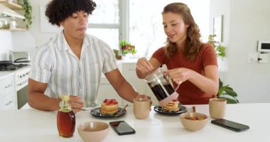 Çeşitli çiftler kahvaltıdan zevk alıyor, modern mutfakta taze böğürtlenlerle krep paylaşıyorlar. romantik, sağlıklı