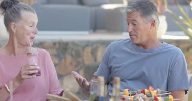 Kıdemli adam çeşitli son sınıf arkadaşlarıyla bahçede yemek yiyor, konuşuyor ve birlikte dinleniyor. Arkadaşlık, eğlence, piknik, bahçede, kaynaşma, toplanma.