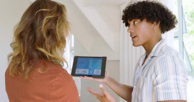 Çeşitli çiftler akıllı ev özelliklerini kontrol etmek için tablet kullanıyorlar, ayarları birlikte tartışıyorlar. teknoloji, otomasyon, bağlantı, modern, kolaylık, yaşam tarzı