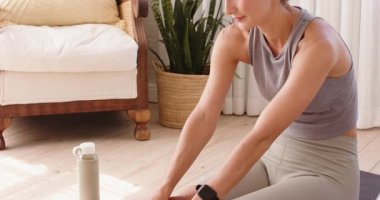 Evde yoga minderinde uzanan bir kadın esneklik ve sağlığa odaklanıyor. egzersiz, fitness, farkındalık, rahatlama, sağlıklı yaşam tarzı