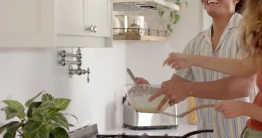 Çeşitli çiftler mutfakta birlikte yemek pişiriyor, malzemeleri karıştırıyor ve evde eğleniyorlar. yerli, yemek hazırlama, birliktelik, ev, kaynaşma