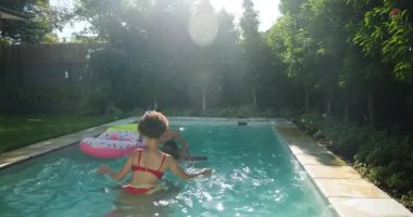 Çeşitli arkadaşlar havuzda güneşli bir günün tadını çıkarıyorlar, gülüyorlar ve şişme halkayla oynuyorlar. Tatil, açık hava, boş zaman, su, yaz, arkadaşlık