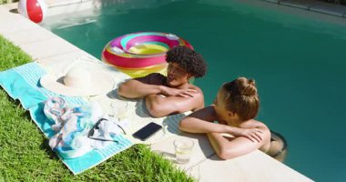 Havuz başında rahatlayan, çeşitli çiftler, güneşli bir günün tadını çıkarıyorlar. İçkiler ve şişme yüzükle. Tatil, tatil, rahatlama, yaz, havuz başı, güneş ışığı.