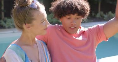 Havuzda rahatlayan, güneşli günün tadını çıkaran ve birlikte kahkaha atan genç bir çift. Tatil, tatil, rahatlama, yaz, bağ, mutluluk.