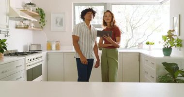 Mutfak tadilatı, dijital tablet kullanarak evde tasarım fikirlerini tartışan çeşitli çiftler. Tartışma, iç tasarım, teknoloji, beyin fırtınası.