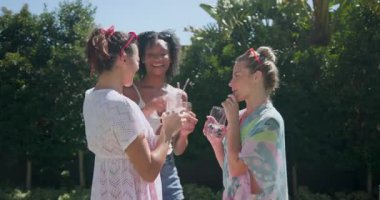 Çeşitli bayan arkadaşlar havuz başında içeceklerin keyfini çıkarıyorlar, gülüyorlar ve dışarıda eğleniyorlar. Boş zaman, yaz, tatil, arkadaşlık, rahatlama, havuz başı