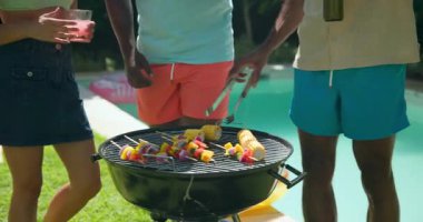 Çeşitli arkadaşlar güneşli bir günde havuz başında içkinin ve kahkahanın tadını çıkarıyorlar. Boş zaman, yaz, rahatlama, parti, sosyalleşme, yaşam tarzı