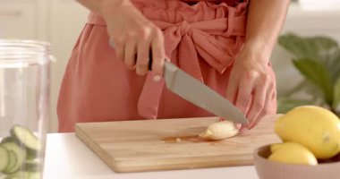 Mutfakta tahta kesme tahtasında muz dilimleyen bir kadın, sağlıklı yemek hazırlıyor. Yemek pişirme, hazırlık, sağlıklı beslenme, meyve, beslenme, aşçılık