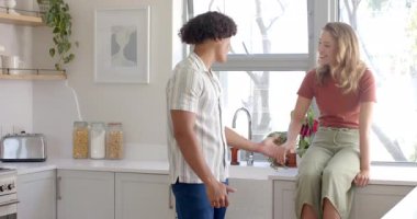 Modern mutfakta eğlenceli bir şekilde dans eden mutlu çift, evde birlikte güzel vakit geçiriyorlar. Mutluluk, ilişki, ev, yaşam tarzı, bağlanma, eğlence