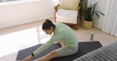 Evde yoga yapan bir kadın, esneme egzersizleri yapıyor, fotokopi çekiyor. fitness, sağlık, meditasyon, ev çalışması