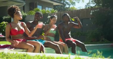 Havuzda rahatlamak, farklı arkadaşlar içki ve güneş ışığını paylaşmak, birlikte mutlu anlar yaşamak. Tatil, tatil, havuz kenarı, rahatlama, arkadaşlık, yaz