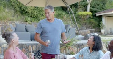 Bahçe partisinde çeşitli yaşlılardan oluşan bir grup bahçede içki içip sohbet ediyorlar. Yaşlılar, sosyalleşme, içecekler, etkinlik, toplanma, arkadaşlık