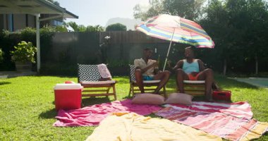 Çeşitli arkadaşlar havuzda rahatlıyor, güneşli bir günde renkli şemsiyeler altında selfie çekiyorlar. Tatil, rahatlama, yaz, boş zaman, grup, arkadaşlık