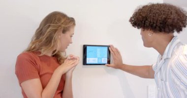 Akıllı ev kontrol paneli ayarlanıyor. Çeşitli çiftler merak ve ilgi gösteriyor. Teknoloji, otomasyon, yenilik, etkileşim, keşif