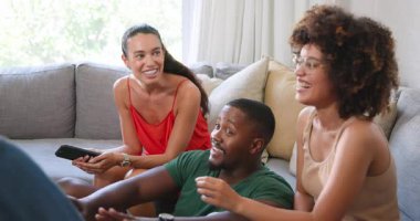 Çeşitli arkadaşlar kanepede dinleniyor, evde sohbetin ve kahkahanın tadını çıkarıyor. Rahatlama, mutluluk, rahatlama, bağlanma, gündelik, arkadaşlık