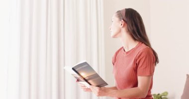 Evde, kadın huzurlu bir ifadeyle kitap okuyor, kanepede dinleniyor. Rahatlama, rahatlama, yaşam tarzı, konfor, sükunet, kapalı alan