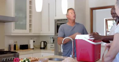 Renkli sebze şişleri hazırlamak, modern mutfakta, evde çeşitli kıdemli arkadaşlar yemek pişirmek. Mutfak, arkadaşlık, takım çalışması, sağlıklı beslenme, hafta sonu, sosyalleşme.